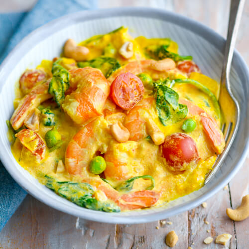 Délicieux curry de crevettes aux épinards, petits pois et tomates cerises